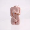A beautifully crafted candle shaped like a female torso without a head, capturing elegant details of the body in soft, nude tones. One arm delicately crosses over the chest, while the other hand rests just above the thigh, creating an intimate and artistic pose. The smooth surface of the candle catches light gently, enhancing its form and texture. This unique piece not only serves as a decorative element but also adds a warm, inviting glow when lit, embodying the spirit of sensual candles. Its minimalist design stands out against a plain background, making it an ideal addition to any romantic setting.