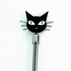 A beginner role play paddle made of stainless steel features a playful black cat design at the top against a clean white background. The cat's face, with large white eyes and a cute red nose, is detailed with whiskers extending from the sides. The sleek, coiled handle adds a modern touch, making this paddle both adorable and functional for those new to role play, highlighting its friendly and approachable design.