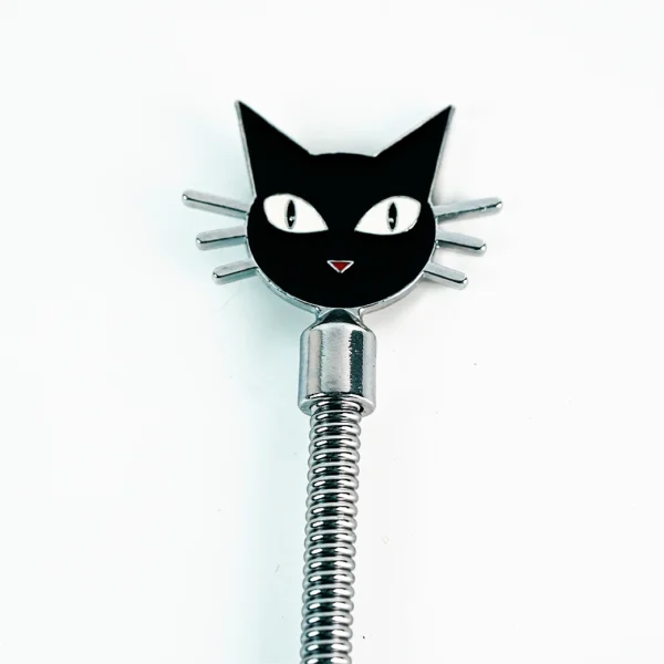 A beginner role play paddle made of stainless steel features a playful black cat design at the top against a clean white background. The cat's face, with large white eyes and a cute red nose, is detailed with whiskers extending from the sides. The sleek, coiled handle adds a modern touch, making this paddle both adorable and functional for those new to role play, highlighting its friendly and approachable design.