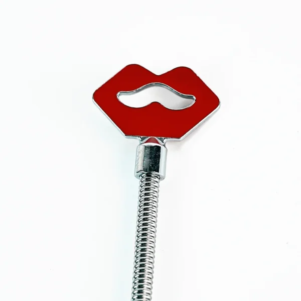 A beginner role play paddle made of stainless steel features a fun red lips design at the top, showcasing a playful cutout of a mustache in the center. The sleek, shiny handle is coiled for a comfortable grip, emphasizing a modern and stylish design. Set against a clean white background, this paddle is perfect for those new to role play, combining charm and functionality in one unique piece.