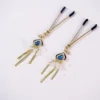 A pair of luxurious BDSM nipple clamps is displayed against a clean white background. The clamps feature a delicate gold design, adorned with shimmering blue gemstones and transparent flower accents. Each clamp has rubber tips for comfort and smooth edges, while hanging chains with decorative strands add a playful touch. This stylish and elegant design makes them perfect for those exploring BDSM dynamics with both functionality and flair.