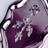 A luxurious clamps are beautifully displayed on a polished silver tray. The clamps feature an ornate design with sparkling silver detailing, highlighted by a central lavender gemstone and intricate floral accents. Dainty chains adorned with various sparkling crystals dangle elegantly, adding a touch of glamour. This exquisite piece combines functionality with a chic aesthetic, perfect for those exploring role play dynamics.