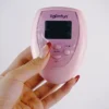 A hand holding a sleek pink remote control from an electro-stimulation bed restraints set. The remote features a clear digital display and multiple buttons, including "ON," "MODE," and "S/P," designed for easy operation. The user’s hand, adorned with stylish red-tipped nails, is poised over the buttons, indicating readiness to engage. Displayed against a soft white background, this modern remote exemplifies innovative bed restraints set, perfect for controlling sensations in playful and intimate settings. Its design combines functionality with a playful aesthetic, enhancing the overall experience.